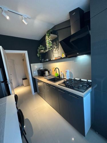 a small kitchen with a stove and a sink at Complex Rediu 54 Luxury Apartaments in Iaşi
