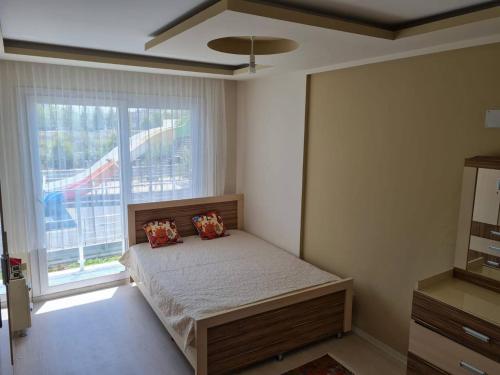 a bedroom with a bed and a large window at Cozy two-room apartment for living in Erdemli