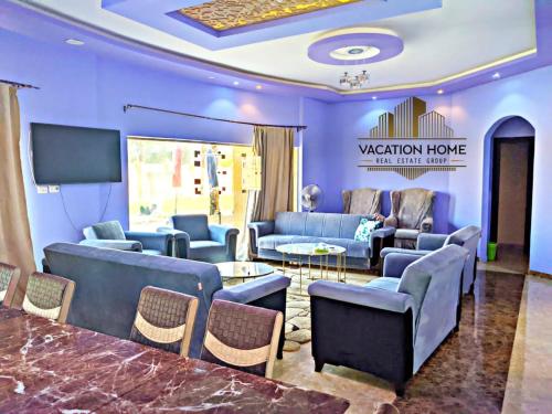 a waiting room with blue furniture and a flat screen tv at الريف الاوروبي طريق مصر إسكندرية الصحراوى in El-Maṣâni`