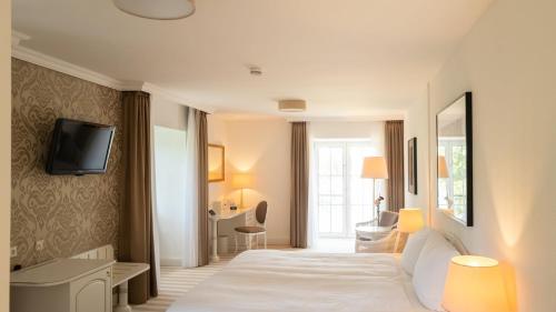 um quarto de hotel com uma cama e uma televisão na parede em nook x Seepalais Boutique Hotel em Bad Saarow