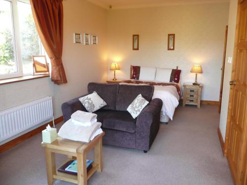 a hotel room with a bed and a couch at Heulwen Guest House in Dolgellau