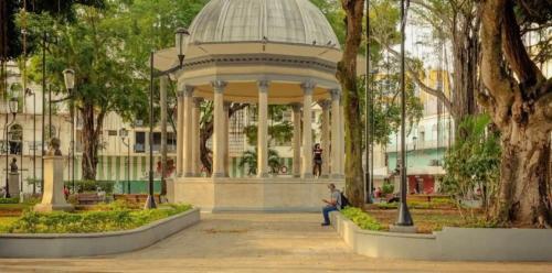 Ein Mann, der vor einem Pavillon im Park sitzt. in der Unterkunft Hotel Caracas in Panama-Stadt