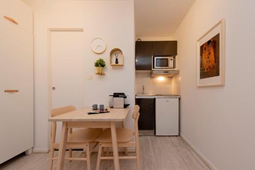 une petite cuisine avec une table et des chaises en bois dans l'établissement Le Roseau Toulousain, à Toulouse