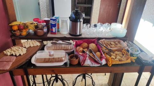 una mesa cubierta con bandejas de comida en una mesa en Hostel Dela, en Tiradentes