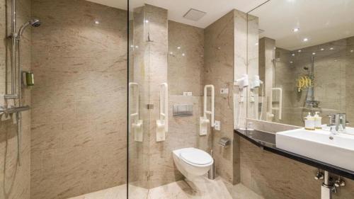 uma casa de banho com um WC, um lavatório e um chuveiro em nook x Seepalais Boutique Hotel em Bad Saarow
