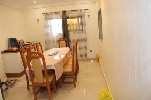 uma sala de jantar com mesa e cadeiras em Villa toute équipée à Arconville em Abomey-Calavi