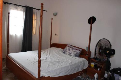 um quarto com uma cama de dossel e uma ventoinha em Villa toute équipée à Arconville em Abomey-Calavi