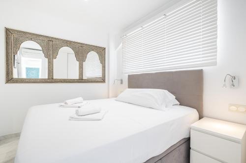 Habitación blanca con cama y espejo en Veracruz 5-C Deluxe Apartment Levante Beach, en Benidorm