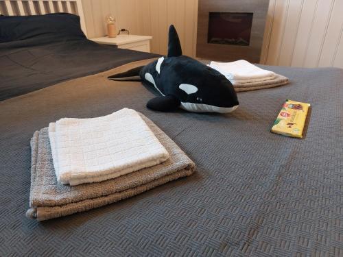 a stuffed whale laying on a bed with towels at In Love With Norway in Larvik