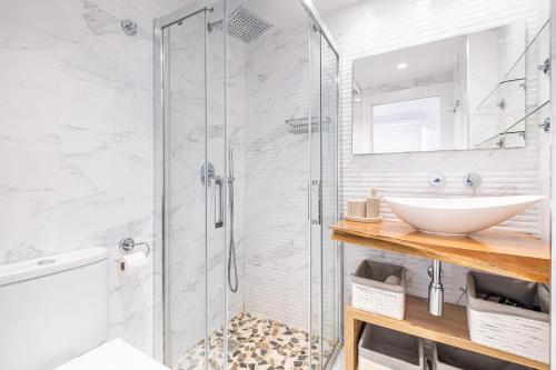 y baño con ducha acristalada y lavamanos. en Veracruz 5-C Deluxe Apartment Levante Beach, en Benidorm