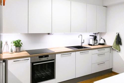 a kitchen with white cabinets and a sink at Fully furnished room for rent in Märsta in Märsta