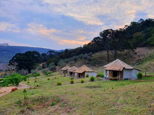 a group of huts on a hill in a field at Espaço Lua Branca in Baependi