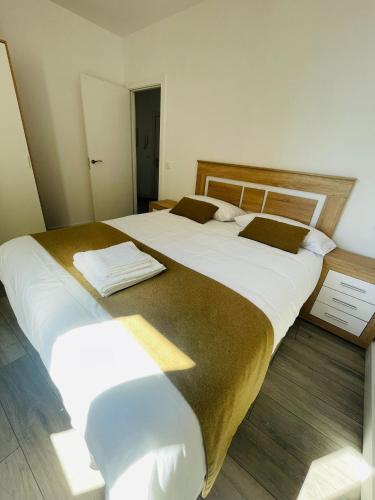 two beds in a room with white and brown sheets at Apartamentos Rurales La Plaza 1 in Duruelo de la Sierra
