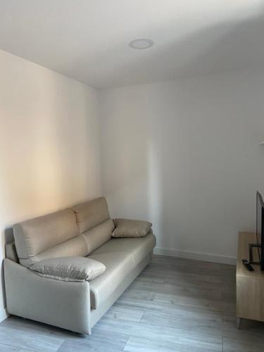 a white living room with a couch in a room at Apartamentos Rurales La Plaza 1 in Duruelo de la Sierra