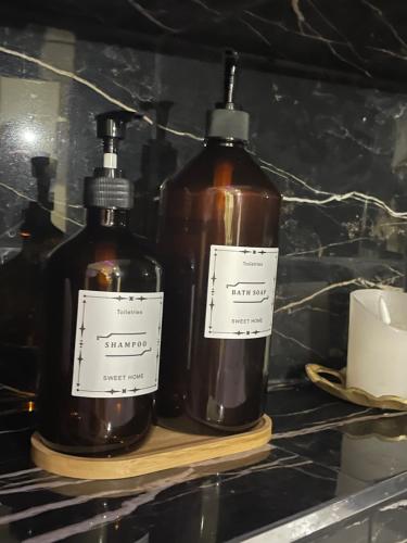 two bottles of alcohol sitting on a shelf at Relax Room proche PARIS Porte de Versailles in Malakoff