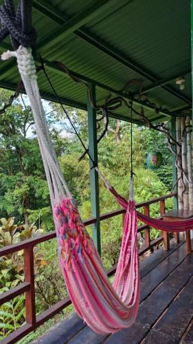 a hammock hanging from a roof on a deck at Vista Alta Ecolodge Bahia Drake in Drake