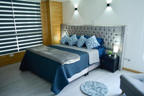 una camera da letto con un grande letto con cuscini blu di Apartamentos cómodos en Milan zona G a Manizales