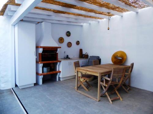 a kitchen with a wooden table and chairs at Casas do Gavião by Portus Alacer in Gavião