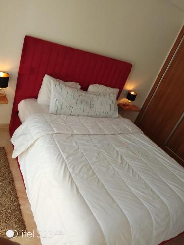 1 cama blanca grande con cabecero rojo y almohadas en Amine sabiri, en Marrakech