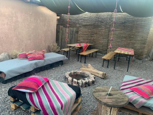 サン・ペドロ・デ・アタカマにあるCabaña Popのベッド2台、テーブル、ベンチが備わる客室です。