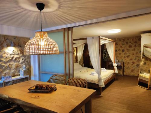 a bedroom with a canopy bed with a table and a dining room at Αλώνι in Nymfasia