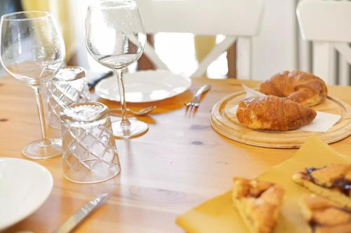 a wooden table with plates of food and wine glasses at Mary House in Sondrio