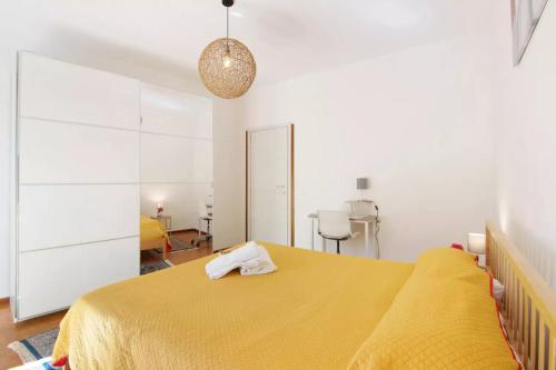 a bedroom with a yellow bed with a yellow blanket at Mary House in Sondrio