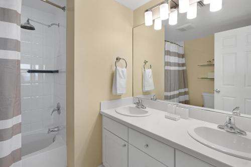 W łazience znajdują się 2 umywalki, prysznic i lustro. w obiekcie Coconut Bay Villas #122 w mieście George Town