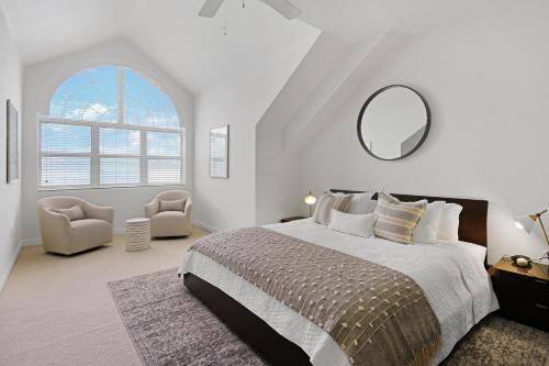 a white bedroom with a large bed and a mirror at Coconut Bay Villas #122 in George Town