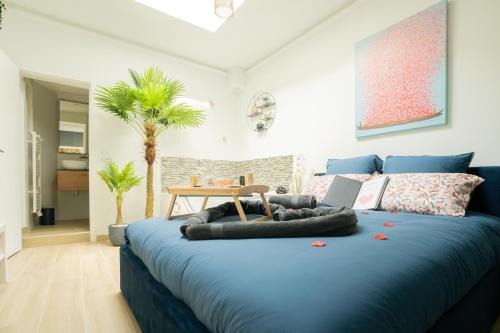 1 dormitorio con cama azul y ordenador portátil en L'Escale Balnéo'Romantique - Maison Cosy - Jacuzzi en Villiers-sur-Marne