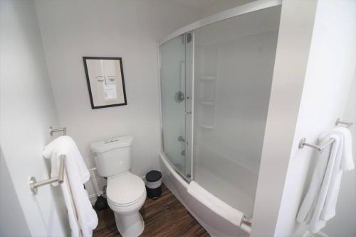 a white bathroom with a shower and a toilet at The Lofts on Clematis 309 Downtown West Palm Beach in West Palm Beach