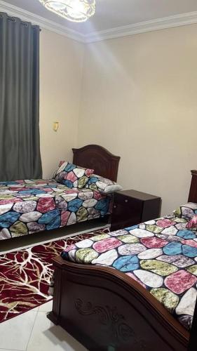 two beds sitting next to each other in a bedroom at شقة مفروشة للايجار فندقية عباس العقاد in Cairo