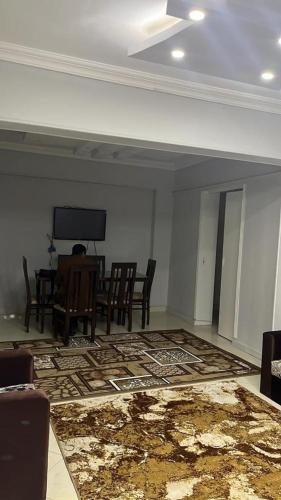 a room with a table and chairs and a television at شقة مفروشة للايجار فندقية عباس العقاد in Cairo