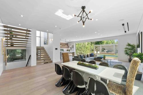 a dining room and living room with a table and chairs at Hollywood Hills 5 BR Villa, Pool, Rooftop, Parking in Los Angeles