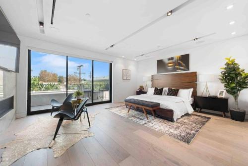 a bedroom with a large bed and a large window at Hollywood Hills 5 BR Villa, Pool, Rooftop, Parking in Los Angeles