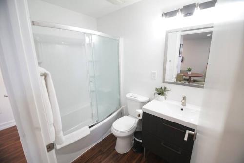 uma casa de banho com um chuveiro, um WC e um lavatório. em The Lofts on Clematis 407 Downtown West Palm Beach em West Palm Beach