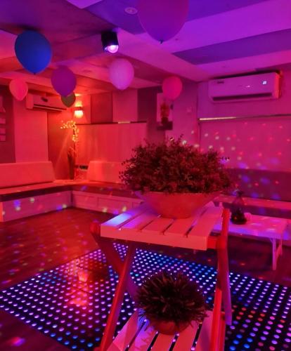 fioletowy pokój ze stołem i doniczką w obiekcie Party boat w Abu Zabi