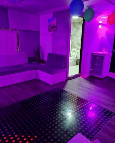 ein Wohnzimmer mit lilafarbener Beleuchtung und einer Couch in der Unterkunft Party boat in Abu Dhabi