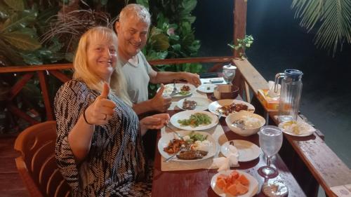 a man and a woman sitting at a table eating food at Yohana Cottage in Tual