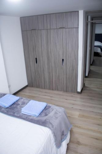 a bedroom with a bed and a wooden closet at Apartamentos cómodos en Milan zona G in Manizales