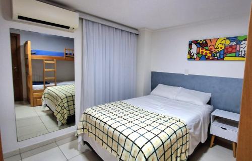um quarto de hotel com uma cama e um espelho em LUXOR CABO BRANCO - JOIA RARA Beira Mar em João Pessoa