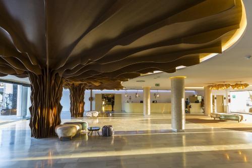 a lobby with a tree growing out of the ceiling at Grand Palladium White Island Resort & Spa - All Inclusive in Playa d'en Bossa