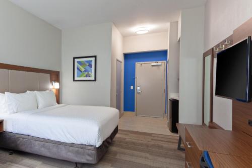 a hotel room with a bed and a flat screen tv at Holiday Inn Express Mira Mesa San Diego by IHG in Mira Mesa