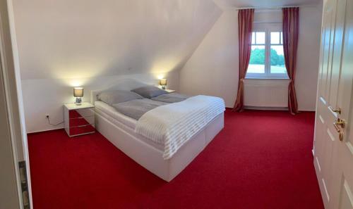um quarto com uma cama branca e um tapete vermelho em Ferienwohnung für 4 Personen in bester Lage ca. 15 km von Bremen City em Achim