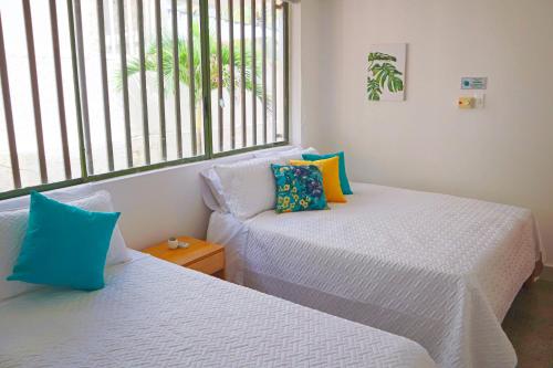 Zimmer mit 2 Betten, einem Sofa und einem Fenster in der Unterkunft Magico Apartamento Frente al Mar 3 Habitaciones C11A in Coveñas