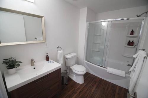 a bathroom with a shower and a toilet and a sink at The Lofts on Clematis 505 Downtown West Palm Beach in West Palm Beach