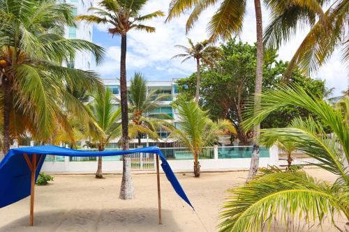 eine Schaukel am Strand mit Palmen in der Unterkunft Magico Apartamento Frente al Mar 3 Habitaciones C11A in Coveñas