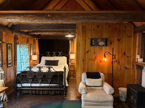 ein Schlafzimmer mit einem Bett und zwei Stühlen in einem Zimmer in der Unterkunft Romantic, Tranquil Guest House in Fitzwilliam