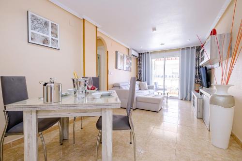 - un salon avec une table, des chaises et un canapé dans l'établissement Deluxe Apartment Playa del Cura, à Torrevieja