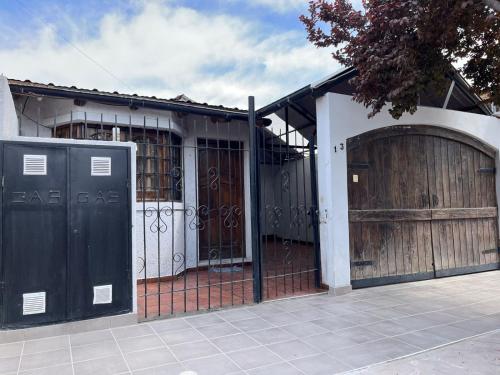 une maison avec deux portes de garage et une clôture dans l'établissement Complejo Lamadrid - semiprivado, à Luján de Cuyo